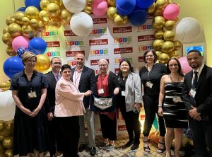 Group of bankers in front of a wall of balloons.